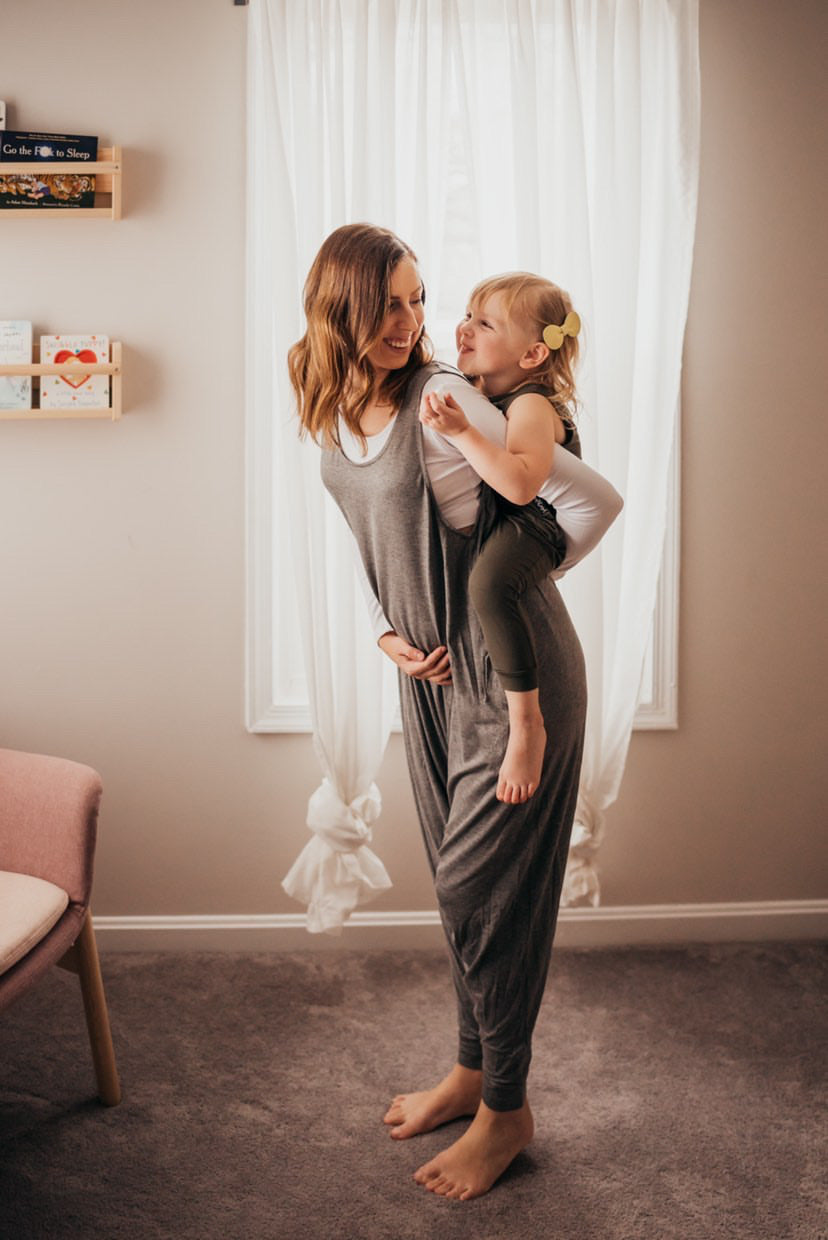 Matching mom and daughter rompers in gray.